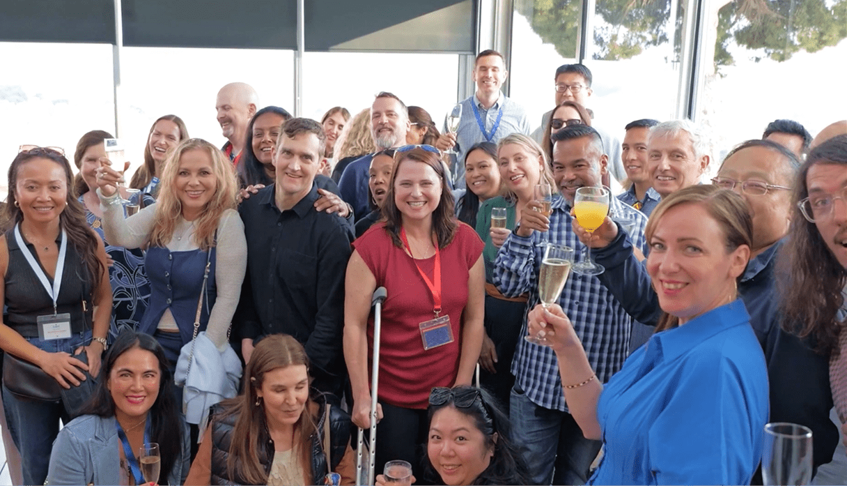 A large group of smiling Structure Therapeutics employees gathers closely together for a group photo in a bright indoor setting.
